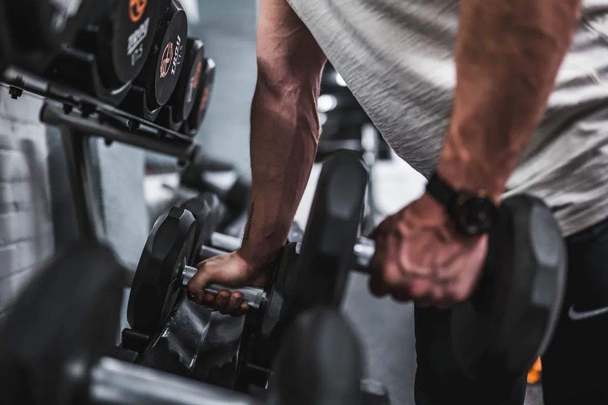 Femme soulevant des haltères en salle de gym — musculation féminine et apport protéique pour la tonification musculaire